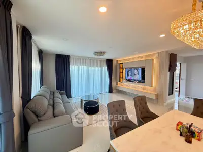 Luxurious living room with elegant decor and modern furnishings, featuring a plush sofa and stylish chandelier.
