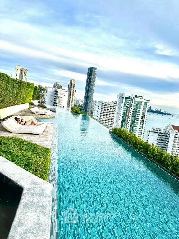Luxurious rooftop infinity pool with stunning city and ocean views in a high-rise building.