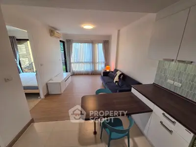 Modern open-plan living room with stylish kitchen and cozy bedroom view