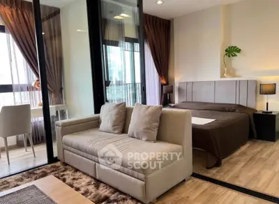 Modern studio apartment with stylish decor, featuring a cozy bed, elegant sofa, and floor-to-ceiling windows.