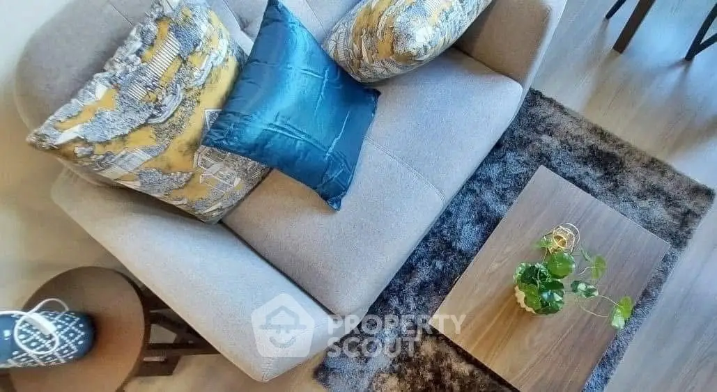 Stylish living room with modern sofa and decorative cushions, elegant coffee table, and cozy rug.