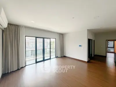 Spacious living room with large windows and balcony access in modern apartment.