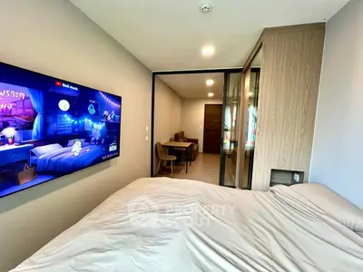 Modern bedroom with wall-mounted TV and cozy decor