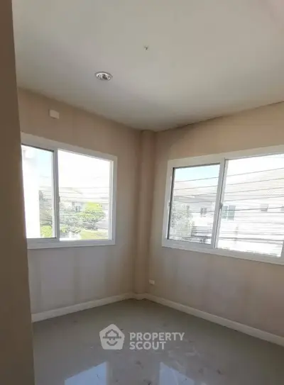 Bright corner room with large windows offering ample natural light and neighborhood views.