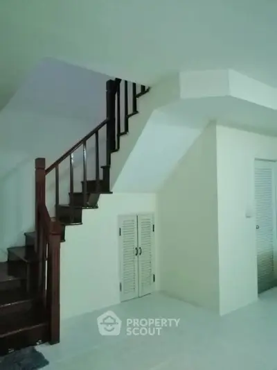 Spacious interior with elegant staircase and storage under stairs, perfect for modern living.