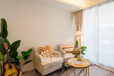 Cozy living room with natural light, stylish decor, and comfortable seating.