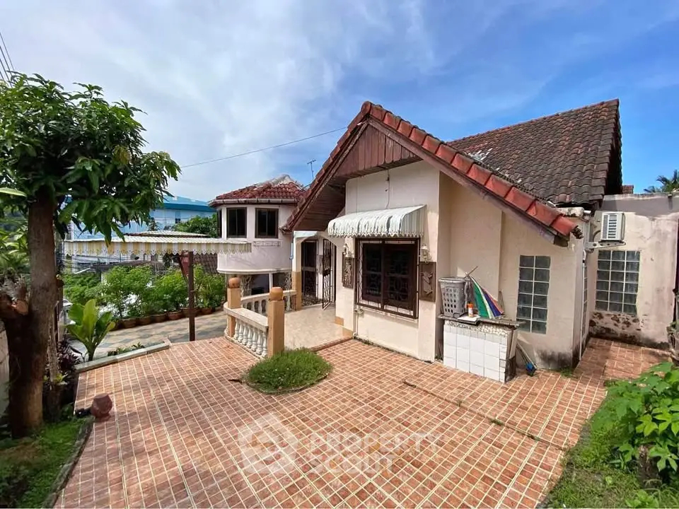 Charming rustic house with tiled roof and spacious outdoor patio in a serene neighborhood.