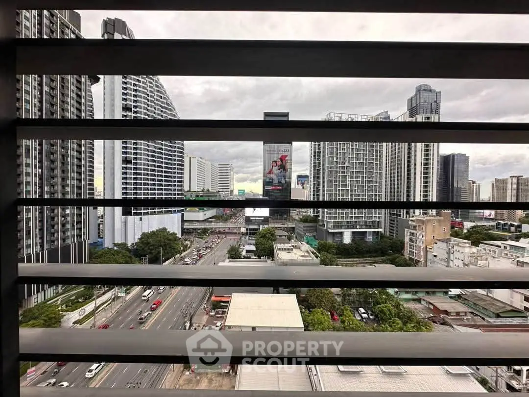Stunning urban cityscape view from a high-rise balcony, showcasing modern architecture and bustling streets.