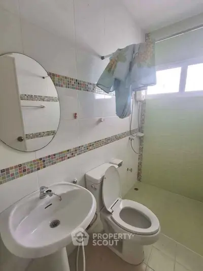 Compact bathroom with modern fixtures and colorful tile accents