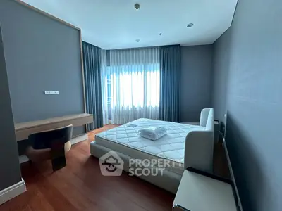 Modern bedroom with large window and stylish furniture in a cozy apartment.