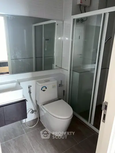 Modern bathroom with sleek design featuring glass shower and contemporary fixtures.