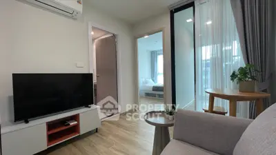 Modern living room with TV, air conditioning, and view into bedroom