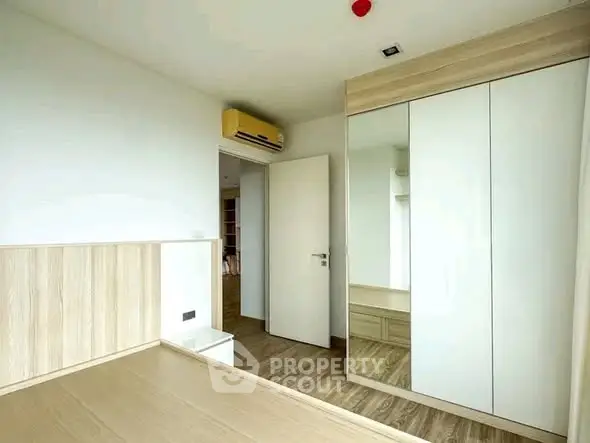 Modern bedroom with built-in wardrobe and air conditioning unit