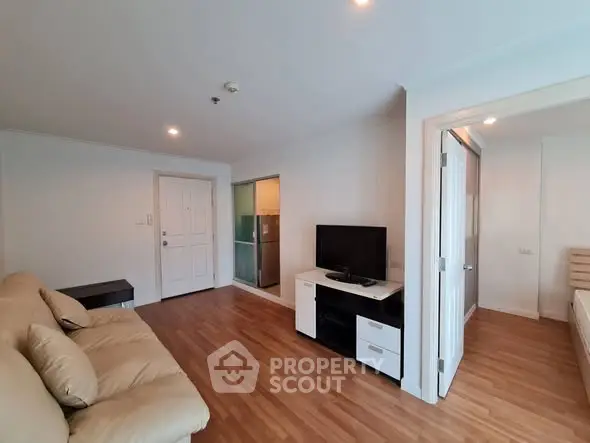 Spacious living room with modern decor and wooden flooring in a stylish apartment.