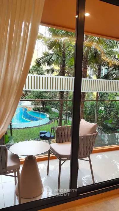 Luxurious balcony view with pool and lush garden, perfect for relaxation and leisure.