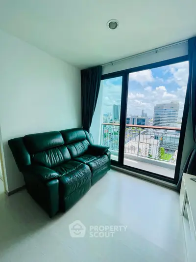 Modern living room with black leather sofa and city view from large window.