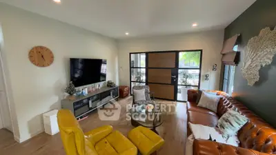 Stylish living room with modern decor, leather sofas, and large TV, perfect for relaxation and entertainment.