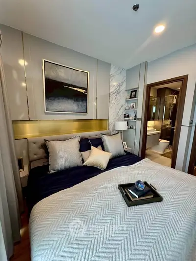 Luxurious bedroom with elegant decor and ensuite bathroom in modern apartment.