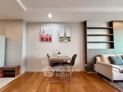 Modern living room with stylish decor and wooden flooring, featuring a cozy dining area and comfortable seating.