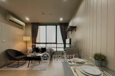 Modern living room with stylish decor and large window offering natural light.