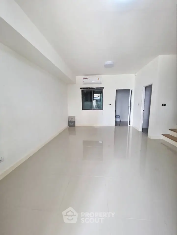 Spacious modern living room with sleek tiled flooring and minimalist design.