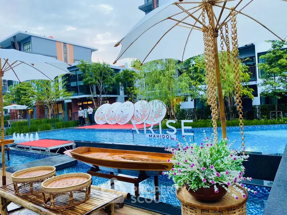 Luxurious poolside view with elegant decor and lush greenery at Rise Mahidol.