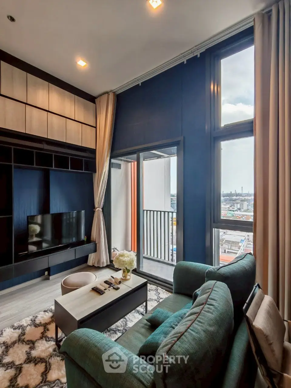 Luxurious living room with modern decor and stunning city view from balcony.