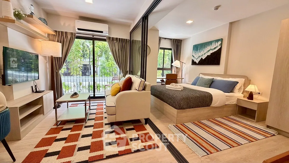 Modern studio apartment with stylish decor, featuring a cozy living area and a comfortable bed near a large window.