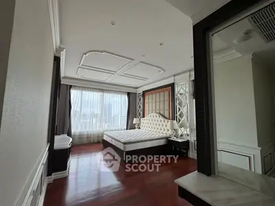 Luxurious bedroom with elegant decor and city view, featuring a plush bed and hardwood floors.