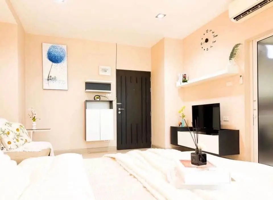 Modern living room with stylish decor and wall-mounted TV, featuring cozy seating and contemporary design.