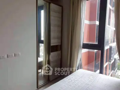 Modern bedroom with large window and city view in high-rise apartment