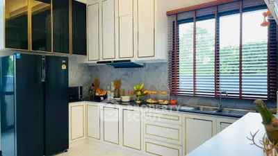 Luxurious modern kitchen with sleek cabinetry and large window for natural light.