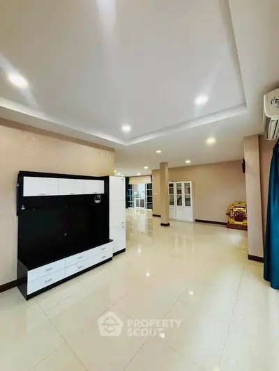 Spacious modern living room with sleek white cabinetry and recessed lighting