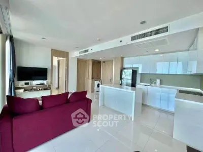 Spacious modern living room with open kitchen and red sofa in luxury apartment