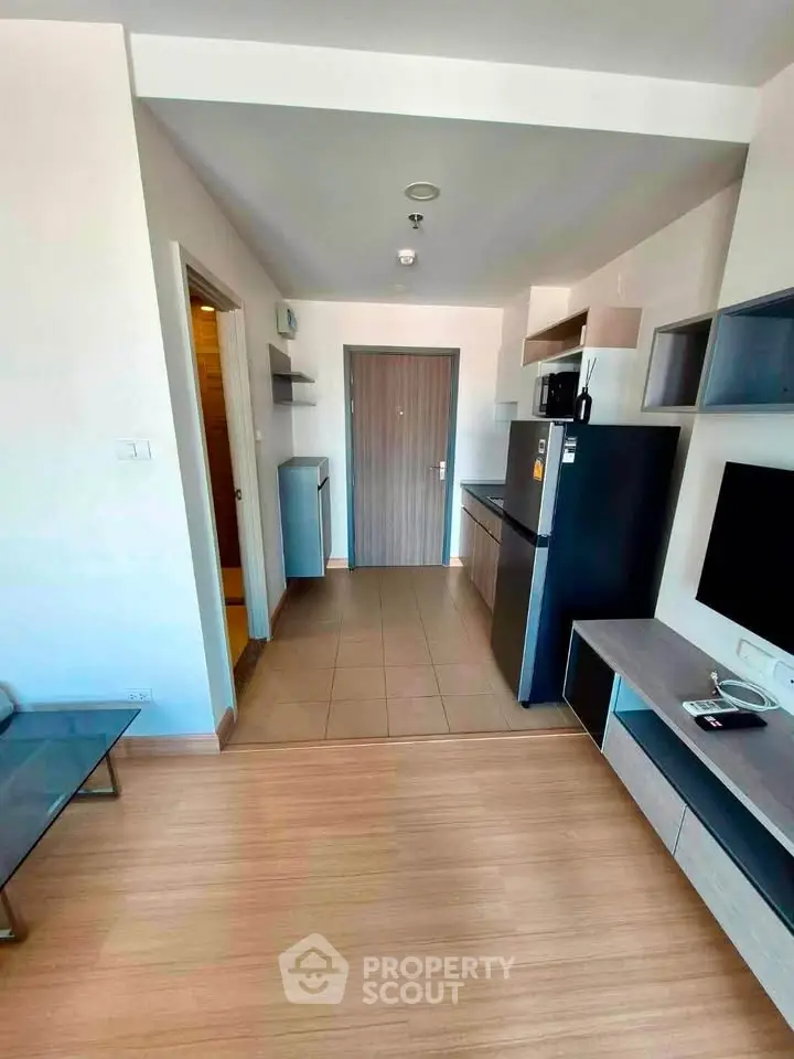 Modern apartment interior with open layout, featuring sleek kitchen and stylish living area.