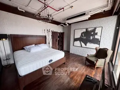 Stylish industrial bedroom with wooden floors and modern art decor