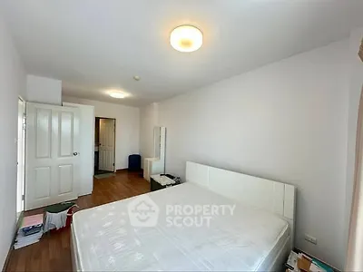 Spacious bedroom with wooden flooring and modern lighting