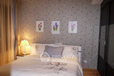 Cozy bedroom with elegant decor and floral artwork, featuring a comfortable bed and soft lighting.