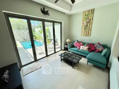 Charming living room with pool view, vibrant decor, and natural light.