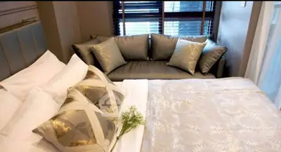 Luxurious bedroom with elegant bedding and cozy seating area, perfect for relaxation.