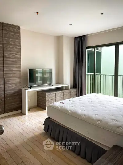 Modern bedroom with large window and sleek furniture in a stylish apartment.
