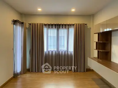 Spacious living room with elegant curtains and modern shelving unit