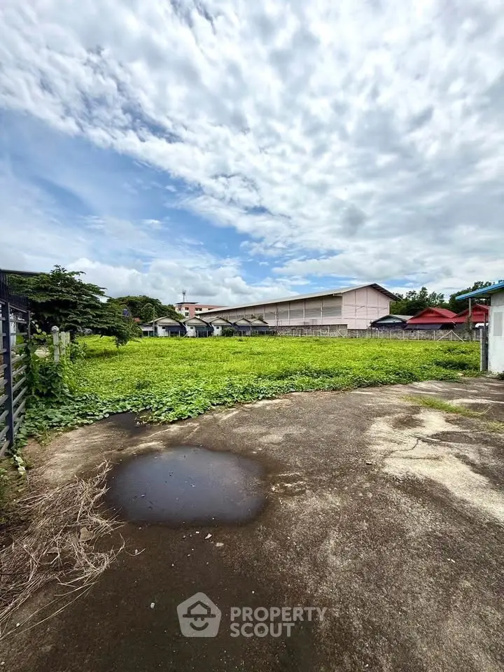 Spacious vacant land with lush greenery and clear sky, ideal for development opportunities.
