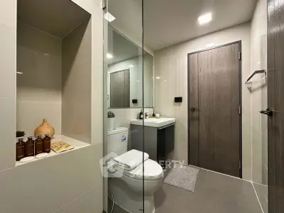 Modern bathroom with sleek design, featuring a toilet, sink, and stylish decor elements.
