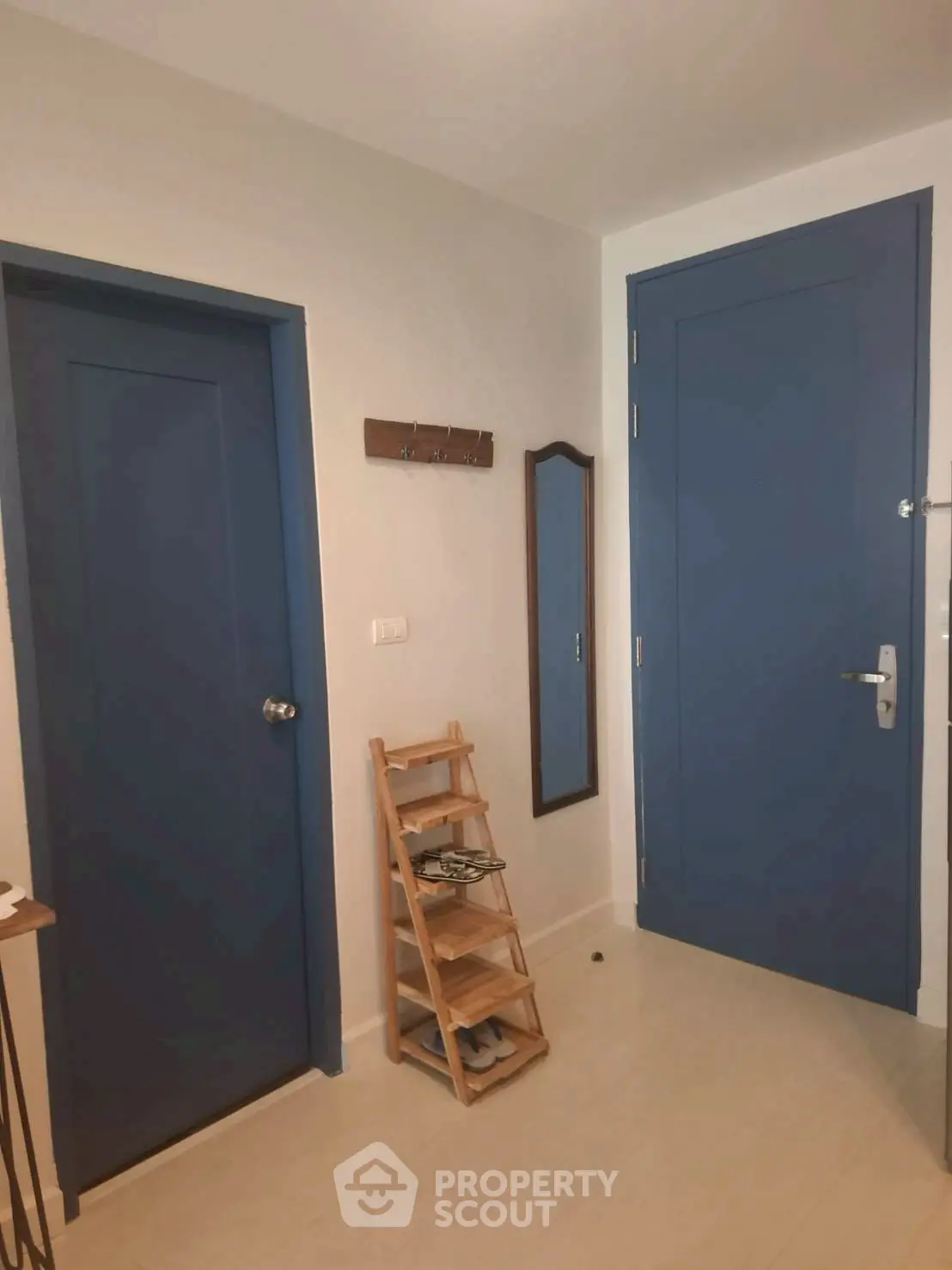 Charming entryway with blue doors and shoe rack, perfect for modern homes.