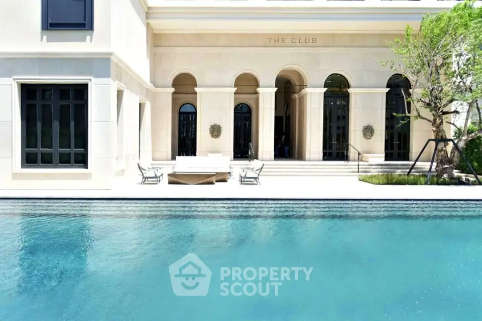 Luxurious poolside view of elegant building with arched entrances and lush greenery.