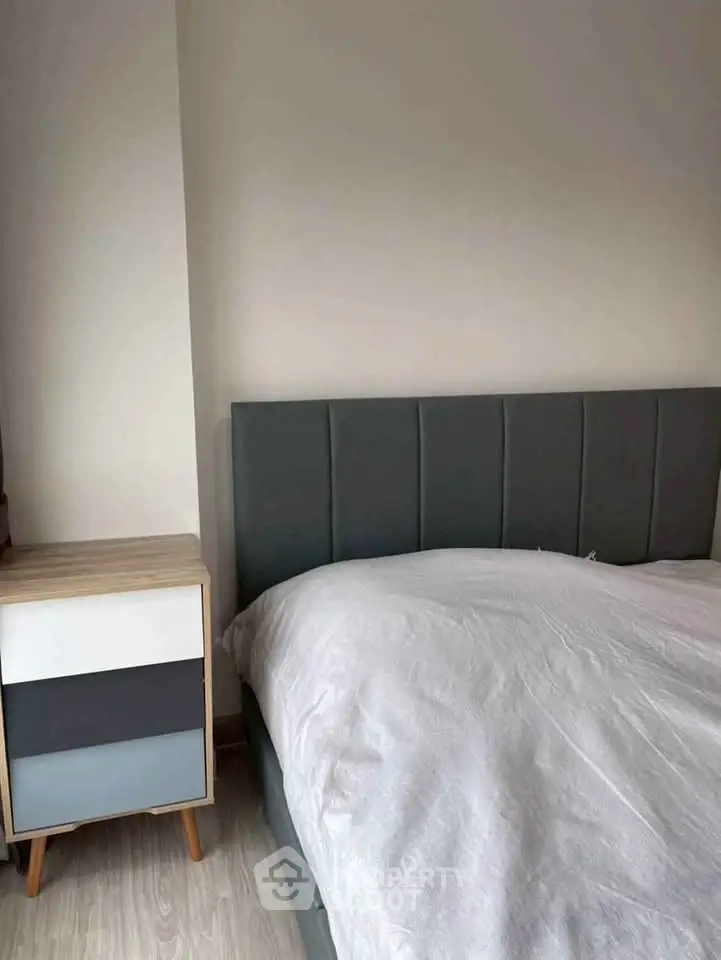 Cozy bedroom with modern bed and stylish nightstand, perfect for relaxation.