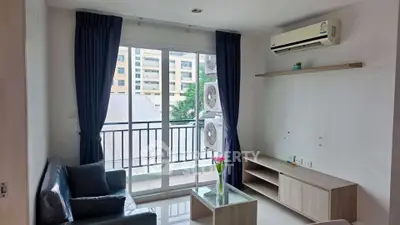 Modern living room with balcony view, sleek furniture, and air conditioning in a stylish apartment.