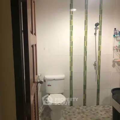 Compact bathroom with shower and toilet, featuring modern tile design and efficient layout.