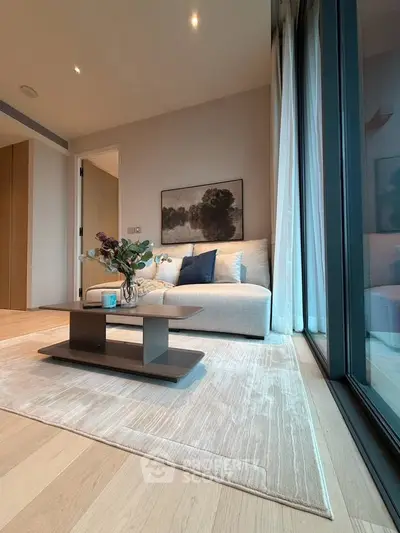 Modern living room with elegant decor and large windows offering natural light.